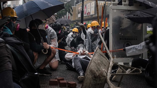 Protestující jsou zachyceni, jak dne 25. srpna 2019 po ukončení protivládního shromáždění vystřelí cihlu z velkého praku, když čelí pořádkové policii v Hongkongu, SAR.