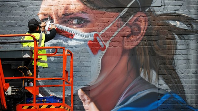 Umělec dokončující graffiti zdravotní sestry v anglickém Manchesteru. (18. října 2020)