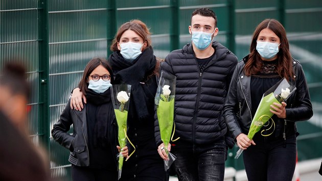 Lidé přinesli květiny na místo činu před vysokou školou Bois d'Aulne po útoku na pařížském předměstí Conflans St Honorine. (17. října 2020)