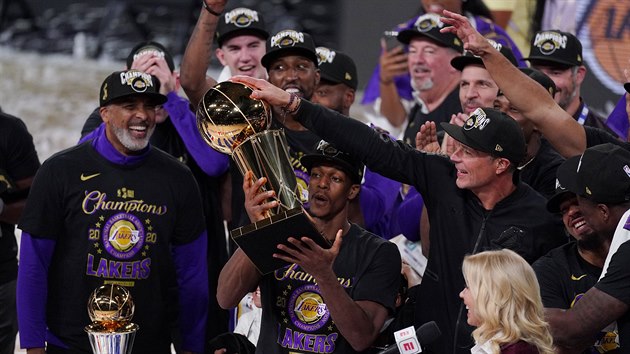 Rajon Rondo z LA Lakers slav s trofej pro ampiony NBA. Vlevo asistent trenra Phil Handy, kter byl u titulu Clevelandu v roce 2016 a Toronta 2019.