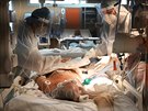 Lékai peují o pacienta s covid-19 na jednotce intenzivní pée v nemocnici v...