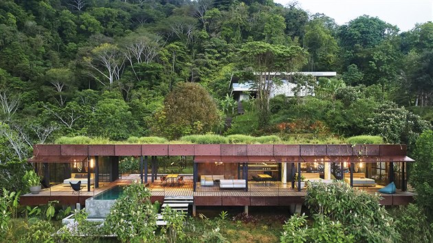 Celý dům o délce 26 m leží v prudkém svahu
a částečně se „vznáší“ nad tropickou vegetací.
Výhledy směřují k oceánu nebo do zelených kopců.