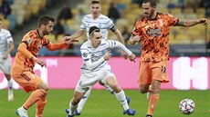 Mykola aparenko (Dynamo Kyjev) sprintuje s míem mezi Rodrigem Betancurem...