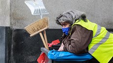 Pracovnice úklidové sluby s roukou na oblieji. (21. íjna 2020)