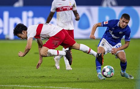 Can Bozdogan (vpravo) ze Schalke a Wataru Endo ze Stuttgartu v souboji o mí.