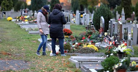 Lidé v roukách zapalují svíky na chebském hbitov v pedveer duiek...