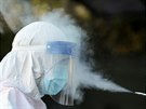 Zdravotník v oblaku dezinfekce po píjezdu do ústedí Bukureské záchranné...
