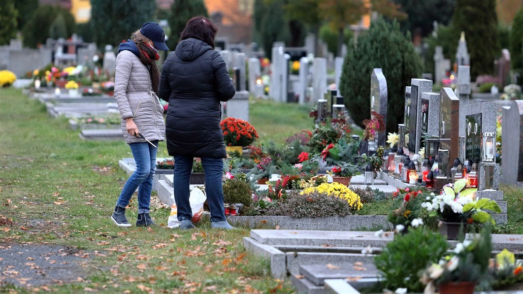 Lidé v rou�kách zapalují sví�ky na chebském h�bitov� v p�edve�er du�i�ek...