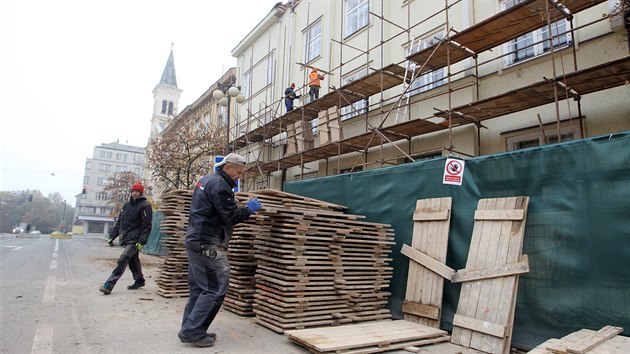 Dělníci staví lešení u budovy v plzeňské Husově ulici, kde se nedávno zřítila římsa a část fasády. Přiléhající část rušné ulice je od té doby uzavřená. (6. 11. 2020)