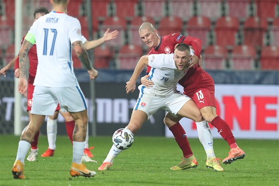 Slovenský obránce Milan kriniar si kryje balon ped eským forvardem Zdekem...