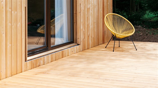 Na velké dřevěné terase, která probíhá přes celou přední fasádu domu, se dá stolovat, jen tak posedět nebo ležet.