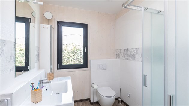 Ponechat pohledovou kvalitu stěn z masivu je možné i v koupelně. Místa exponovaná vodou jsou obložena a dřevěný povrch je ošetřen světlou lazurou, aby si co nejvíce zachoval svůj odstín.
