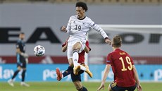 Nmecký záloník Leroy Sane v souboji se panlskými soupei.