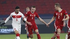 Turecký fotbalista Ozan Tufan uniká Atillu Szalaiovi z Maďarska.