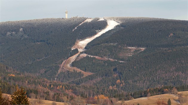 Dole ještě podzim, nahoře už zima. Sjezdovka Jáchymovská, jihozápadní svah, pohled na Klínovec z jáchymovského Nového Města.