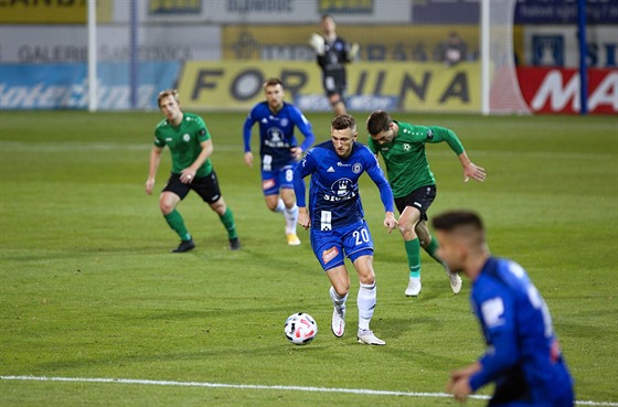 imon Falta (uprosted v modrém) z Olomouce vede balon v zápase proti Píbrami.