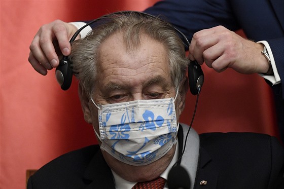 Prezident Miloš Zeman dostává sluchátka se simultánním tlumočením 9. prosince...