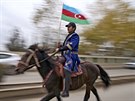 Ázerbájdánský mu v tradiním odvu a s národní vlajkou projídí územím...
