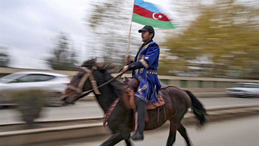 Ázerbájdánský mu v tradiním odvu a s národní vlajkou projídí územím...