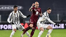 Simone Zaza (uprosted) z Turína FC se dere pes hráe Juventusu k balonu.