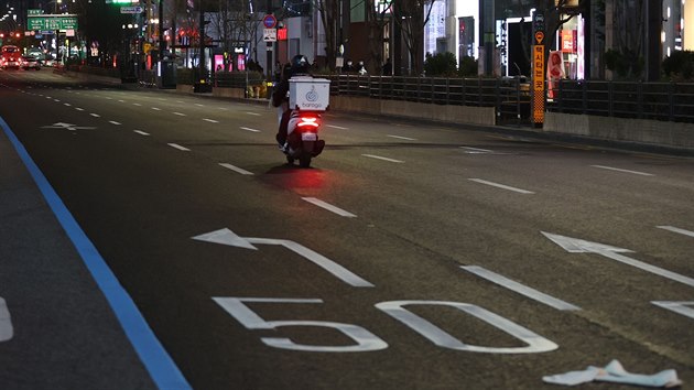 Poslek na motocyklu projd ulic jihokorejskho Soulu. (7. prosince 2020)