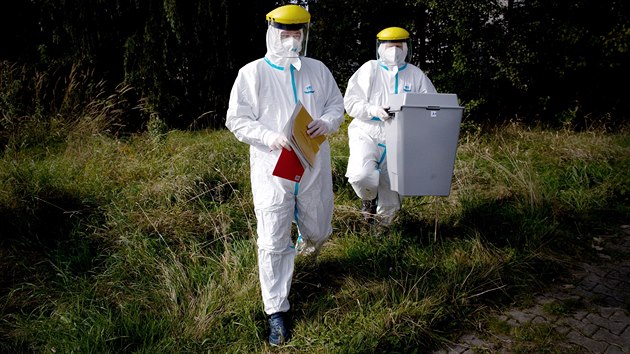 �lenov� volebn� komise v ochrann�ch oblec�ch p�ich�zej� za koronavirem naka�en�m voli�em na plze�sk�m s�dli�ti Lochot�n. (2. ��jna 2020)