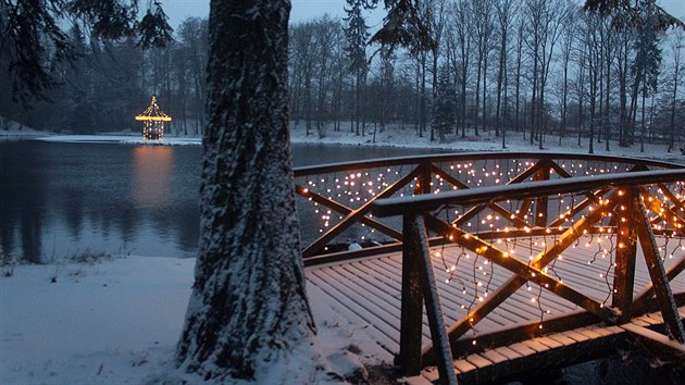 Doln� parkov� rybn�k s And�lsk�m mostem a Zp�vaj�c�m ostrovem p�i prvn� sn�hov� nad�lce.