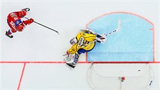 Ruský hokejista Andrej Kuzmenko proti švédskému brankáři Magnusi Hellbergovi