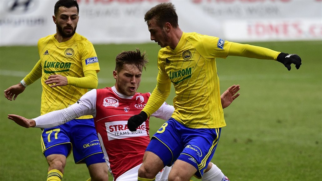Pardubický úto�ník David Huf svádí souboj o mí� mezi zlínskými Jakubem Kolá�em...