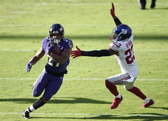 J. K. Dobbins (vlevo) z Baltimore Ravens útoí proti New York Giants, Logan...