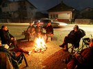 Obyvatelé chorvatské Petrinje se zahívají u ohn. (29. prosince 2020)