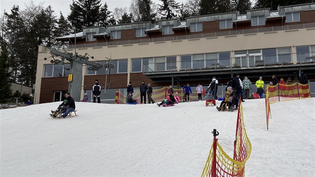 Lidé bobují a sáňkují na vedlejším svahu lyžařského areálu Monínec na Příbramsku. (30. prosince 2020)