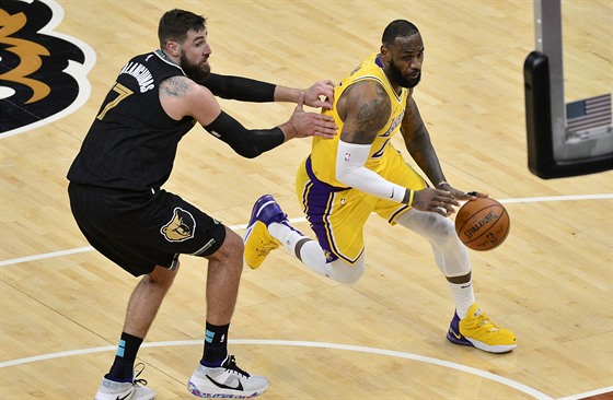 LeBron James z Los Angeles Lakers se tlaí pes Jonase Valanciunase z Memphisu.
