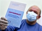 Moskevský senior ukazuje certifikát o okování proti onemocnní covid-19. Úady...