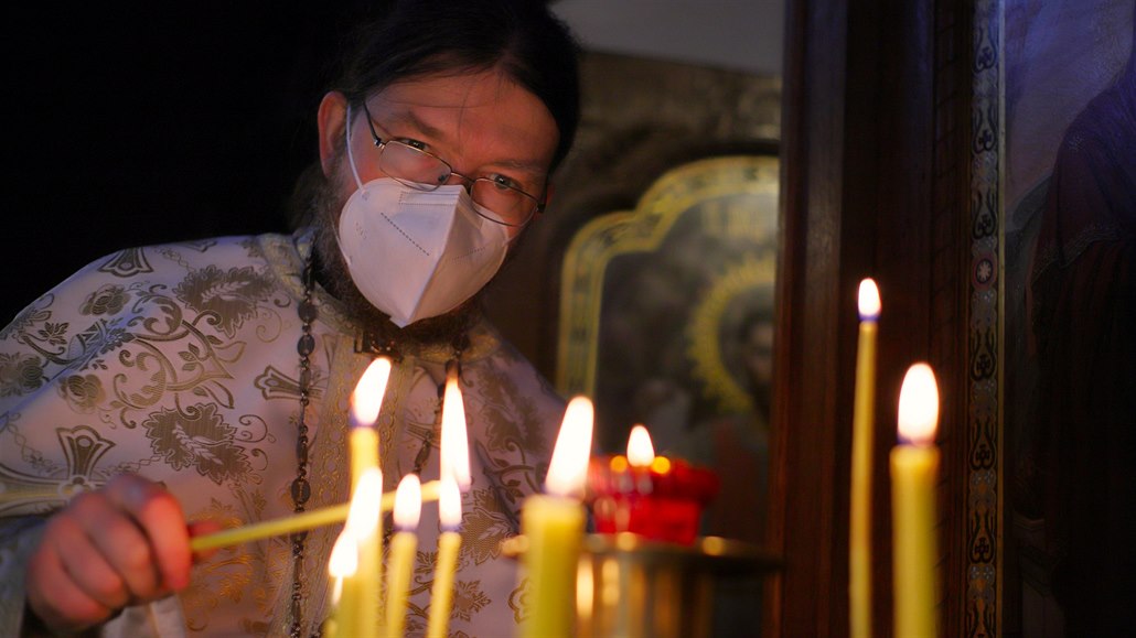 Otec Vít Metoděj Kout zapaluje svíčky před ikonostasem. (8. ledna 2021)