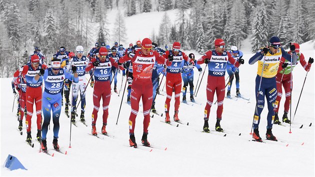 Rus Alexandr Bolunov (uprosted v ervenm) bhem druh etapy Tour de Ski.