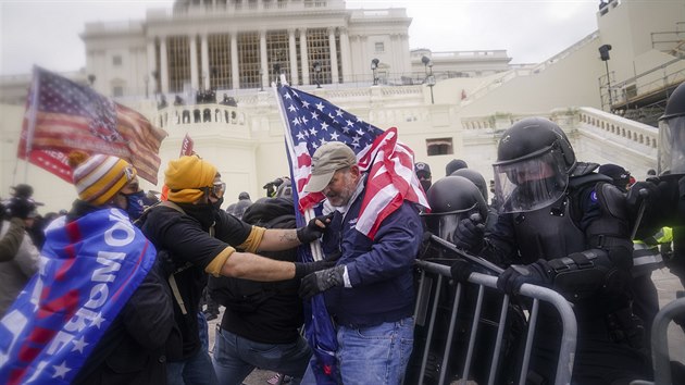 Americk policie se ped budovou Kapitolu ve Washingtonu stetla s demonstranty. Pznivci prezidenta Donalda Trumpa na mst protestovali proti potvrzen volebn porky, kterou na zasedn v budov eil Kongres. (6. ledna 2021)