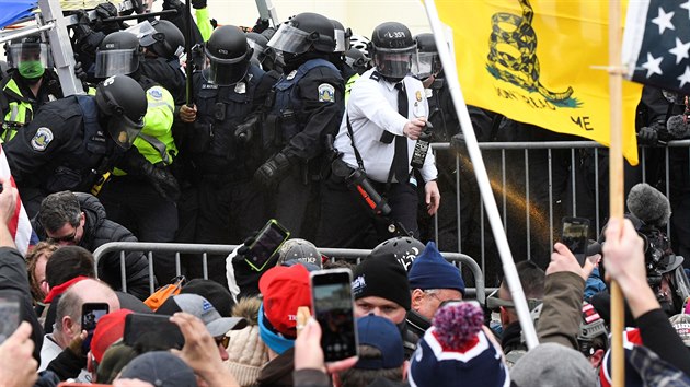 Americk policie se ped budovou Kapitolu ve Washingtonu stetla s demonstranty. Pznivci prezidenta Donalda Trumpa na mst protestovali proti potvrzen volebn porky, kterou na zasedn v budov eil Kongres. (6. ledna 2021)