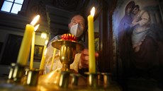 Otec Vít Metodj Kout zapaluje svíky ped ikonostasem. (8. ledna 2021)