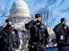 lenové policie chránící americký Kapitol salutují pohebnímu vozu s rakví...