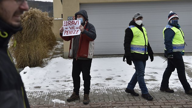 Jeden z odpůrců protestu ukazuje ceduli demonstrantům, kteří před domem ministra zdravotnictví Jana Blatného v Jinačovicích na Brněnsku protestují proti vládním protikoronavirovým opatřením. (16. ledna 2021)