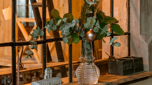 Parapet kuchyňského okna, kterým je vidět do bývalé drážní haly, zdobí váza s čerstvým voňavým eukalyptem.