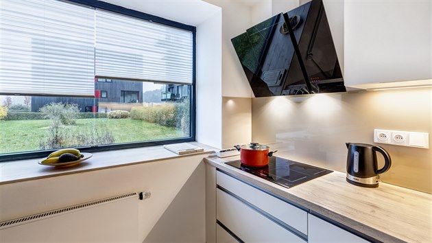 Induk�n� deska nebo kom�nov� odsava� par od �esk�ho v�robce usnad�uj� va�en� a majitelce vylep�uj� komfort v kuchyni. Sklen�n� obklad st�ny nad pracovn� deskou v odst�nu cappuccino byl vyroben� na m�ru.