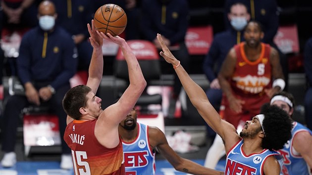 Nikola Joki z Denveru pi stelb, brn ho Jarrett Allen z Brooklynu.