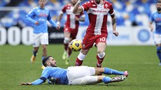 Konstantinos Manolas (na trávníku) z Neapole se snaí skluzem zastavit akci...