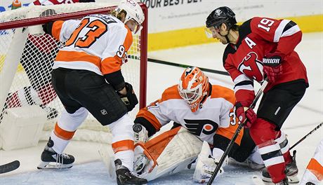 Travis Zajac z New Jersey v anci, branká Philadelphie Brian Elliott ve...