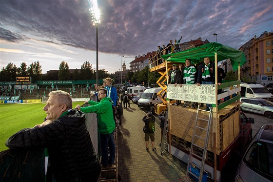Fanouci fotbalist Bohemians 1905 sledují zpoza plotu utkání proti Spart....