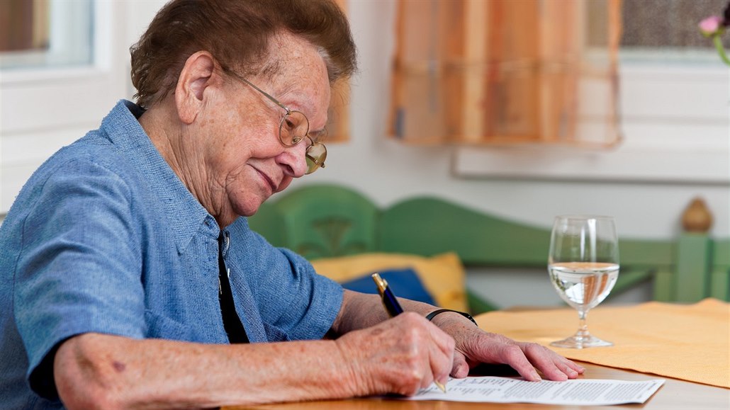 Seniorka podepisuje smlouvu, ilustraní snímek
