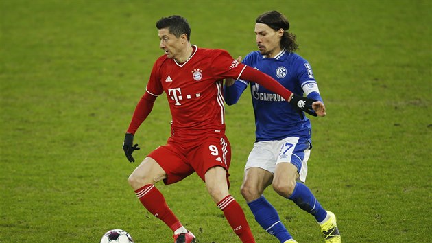 Robert Lewandowski (vlevo) z Bayernu drží balon, zezadu se ho snaží zastavit Benjamin Stambouli ze Schalke.