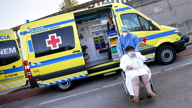Zdravotnk doprovz star pacientku s onemocnnm covid-19 do lisabonsk nemocnice Santa Maria. (21. ledna 2021)